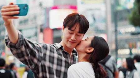 City, kiss and selfie with couple on street together in Japan for bonding, romance or tourism. Love, photograph and smile of Japanese woman with man in urban town for holiday, travel or vacationの写真素材