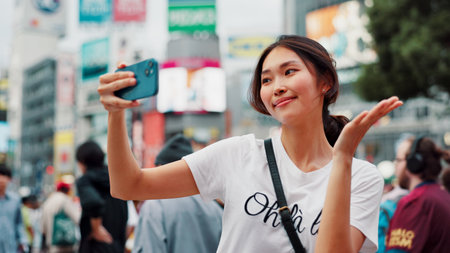 Japanese woman, selfie and happy in city with live streaming of vlogger for content creation. Video, social media and profile picture with showing Tokyo for travel, vacation and app with postの写真素材