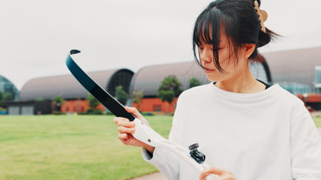 Archery, sport and woman with bow on field for shooting practice, martial arts tradition or getting ready. Japanese culture, archer and equipment safety for kyudo, precision lesson or target trainingの写真素材