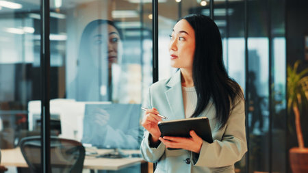 Office, lawyer and businesswoman with tablet for thinking, policy review and digital solution for law firm. Japanese, female person or attorney with ideas for court case, justice report or reflectionの写真素材