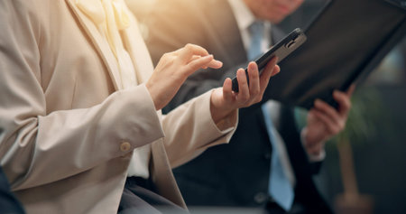 Closeup, hands and typing with phone for job search, research or online application at office. Japan, employee or candidate with mobile smartphone for business network or browsing career at workplaceの写真素材