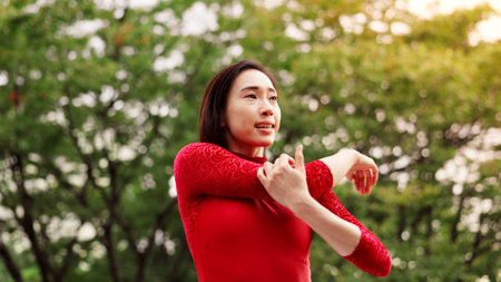 Woman, dancer and stretching arms in park for warm up, fitness or ready for performance in nature. Person, ballet and rehearsal for concert, contest or recital with art, talent and prepare in Japanの写真素材