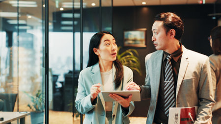 Business, discussion and people walking with tablet for signature on funding request application or proposal review. Accountant, assistant or digital contract for investment approval at Japanese firmの写真素材
