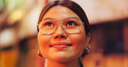 Woman, travel and happy with thinking in city, evening and outdoor for adventure, shopping and street market. Person, smile and perspective with inspiration, reflection and memory on road in Japanの写真素材