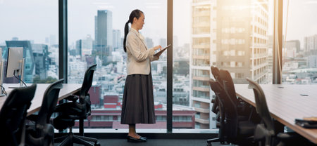 Japan, accountant and woman in office, tablet and typing with internet, website info and connection. Asian person, budget report or employee in workplace, digital app for investment or online readingの写真素材