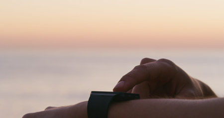 Person, fitness or hands with smart watch at beach for performance, tracking or step counter in nature. Closeup, user or runner with wristwatch for training, sport app or workout goals by ocean coastの写真素材
