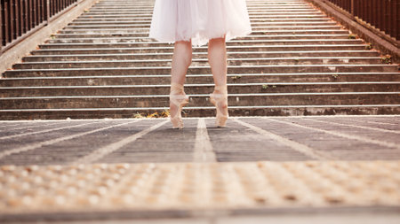 Woman, feet and ballet dancing in city, outdoor and practice performance for art of balance. Female person, professional dancer and creative talent in Japan, rehearsal and urban town for eleganceの写真素材