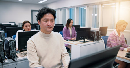 Business people, computer and man with internet, connection and professional. Japan, journalist and consultant in workplace, technology and email with website info, research for article and coworkingの写真素材