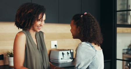 Laughing, happy kid or mom talking to girl for love, connection or bonding together in morning. Child, funny mother and daughter with smile in house, kitchen or family home for joke, care or supportの写真素材