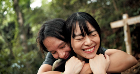 Hug, love and smile with couple in nature for holiday, travel or vacation on mountains of Japan. Anniversary, honeymoon and romance with Japanese people outdoor on Mount Takao together for datingの写真素材