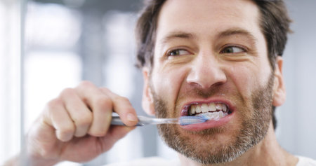 Oral care, bathroom and man brushing teeth for hygiene, wellness and morning routine. Dental health,...