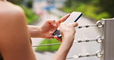Hands, person and typing with phone in city for communication, fitness application and social media. Mobile, discussion and chatting for travel location, sports membership and morning gossip in Japanの写真素材