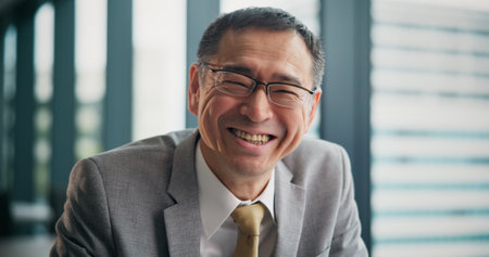 Smile, portrait and Japanese businessman in office with confidence in finance career for company. Happy, pride and mature male financial executive with positive attitude for revenue investment growthの写真素材