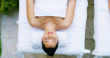 Woman, spa and relax for massage with sleeping for luxury, self care and wellness. Female person, customer and from above on break or resting at resort for body therapy service, treatment or peaceの写真素材