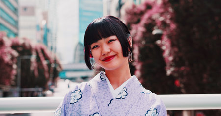 Asian, happy woman and portrait with kimono in city for fashion, festival or tradition. Japan, female person or face with smile or outfit for culture, heritage or travel in an urban town of Tokyoの写真素材