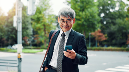 Outdoor, businessman and happy on smartphone on internet for stock exchange rates in Japan. Mature person, city and smile as employee in finance on mobile app for market share or trading returnsの写真素材