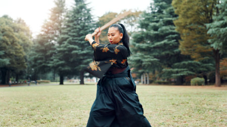 Nature, training and Asian woman with bamboo sword in park for martial arts, Kendo practice and exercise. Culture, bokuto and person with shinai for skills, fitness and traditional sports in Japanの写真素材