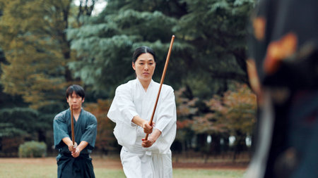 Weapon, Japanese people and outdoor in training, exercise and sports for martial arts or aikido. Student, wooden sword and heritage with challenge, combat and practice as defense technique or bojutsuの写真素材