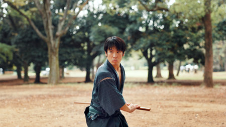Bokken, Japanese man and outdoor for martial arts in training, exercise or sports as athlete. Culture, weapon and male person for heritage, combat and practice for self defense technique with bojutsuの写真素材