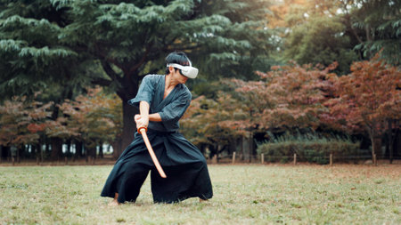 Virtual reality, Japan and Asian man with sword for martial arts, Kendo practice and exercise. Culture, heritage and person with shinai, VR tech and goggles for skills, fight and training in parkの写真素材
