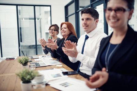 Business people, applause and success in office for goals, happy and profit with meeting at agency. Woman, group and excited with cheers, celebration or achievement in boardroom at insurance companyの写真素材