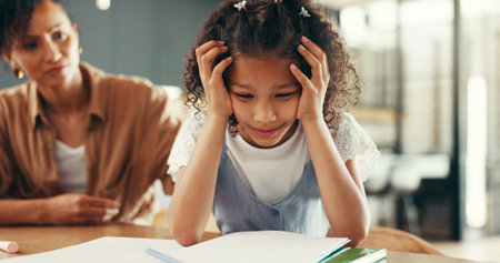 Mom, girl and stress with education, homework and guide for learning disability with books at apartment. People, mother and daughter with care for adhd, development and helping child in family houseの写真素材