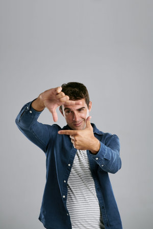 Man, happy and finger frame in studio with photography icon with fashion by white background....