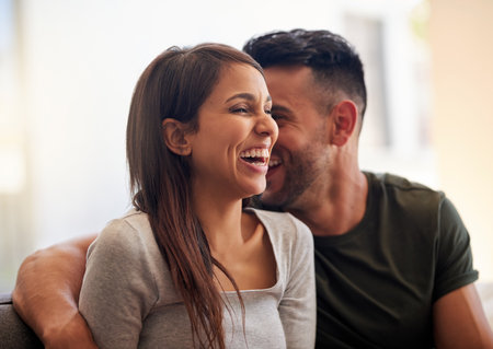 Couple, relax and laugh for watching tv at house for streaming movie, film and multimedia subscription. People, rest and meme with funny entertainment, cinema service and bonding together for comfortの写真素材
