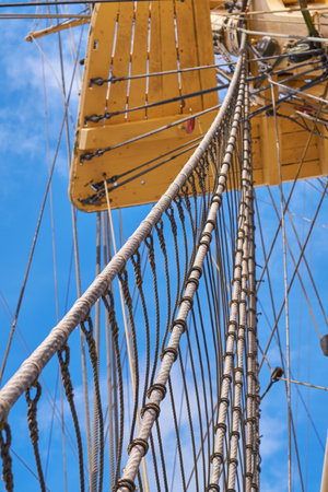 Blue sky, historical and travel with mast of ship outdoor in nature from below for Danish heritage. Culture, engineering and rope with flagpole on sail boat for journey, holiday or vacation at seaの写真素材