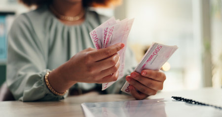 Woman, hands or accountant counting with cash for finance, profit or salary increase at office desk. Closeup, female person or employee with paper bills, financial savings or investment at workplaceの写真素材