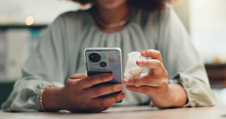 Woman, hands and phone with medication for medical research, side effects or symptoms at office. Closeup, female person or patient with mobile smartphone or pharmaceuticals for search or telehealthの写真素材