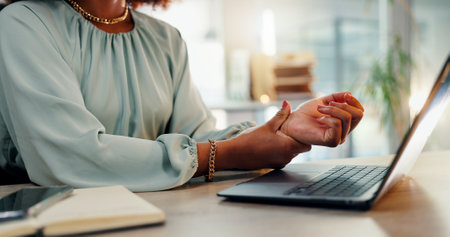 Business woman, hands and wrist injury with laptop for pain, discomfort or carpal tunnel syndrome at office. Closeup, female person or employee with sore palm for joint inflammation, sprain or strainの写真素材