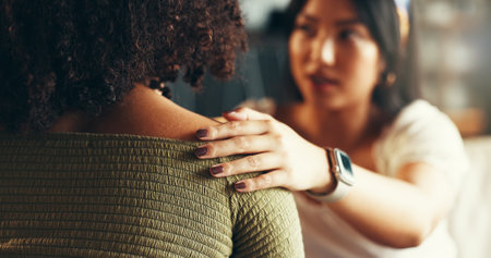 Friends, women and hands on shoulder for support with breakup, depression and relationship advice. Empathy, compassion and person with comfort for stress, overthinking and mental health in apartmentの写真素材