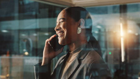 Phone call, night and woman in office, smile and communication with contact, glass and business deal. Happy, talking and person with mobile, laughing and schedule for meeting, publicist and chatの写真素材
