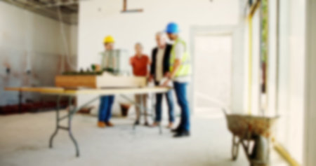 Engineering, meeting and people at blurred construction site for planning, building development and collaboration. Investor, workers and 3D model on table for display, infrastructure and renovationの写真素材