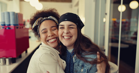 Friends, women and happy in coffee shop with hug, care and bonding at night. Girls, embrace and excited in cafeteria with greeting, support and late reservation for meeting or reunion in urban dinerの写真素材
