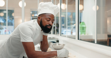 Sleeping, tired and chef with black man in kitchen of coffee shop for overworked, burnout or food industry. Dough, fatigue and cooking with exhausted person in restaurant for cafe, overtime or bakeryの写真素材