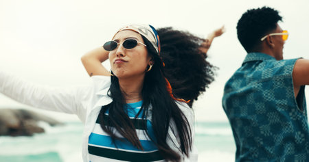 Woman, friends and dancing on beach outdoor with energy, movement and vacation reunion for rave festival. Group, people and rhythm at island party, summer freedom and bonding together of travel tripの写真素材