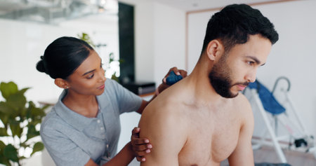 Massage ball, physiotherapy and shoulder with people in clinic for deep tissue pressure, tension and healthcare. Medical, rehabilitation and muscle with woman and man for support, help and healingの写真素材