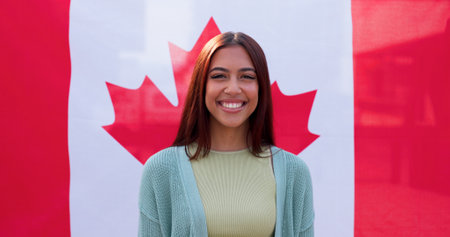Portrait, smile and woman with Canadian flag for national pride, support and heritage. Face, happy and girl with Canada banner on background for patriotism, sports fan and representation for cultureの写真素材