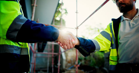 Architecture, closeup and business people with handshake, partnership and contractor. Employees, teamwork and thank you with deal, collaboration and planning for building project and engineeringの写真素材