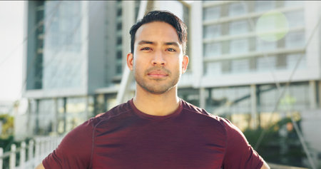 Portrait, exercise and man in city, runner and urban town with buildings, training and sportswear. Face, healthy athlete and Asian person in street, confidence and wellness with workout and prideの写真素材