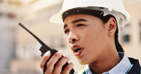 Radio, construction and talking with woman in city for architecture, building site or communication. Engineer, contractor and project manager with person in outdoor for urban development updateの写真素材