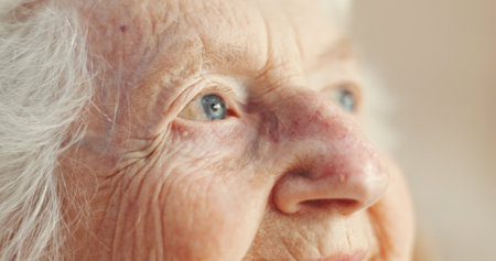 Thinking, senior woman and relax at retirement home for past life, nostalgia and remember with memory. Sad, elderly person and closeup of reflection, loneliness and hope with peace of future wellnessの写真素材