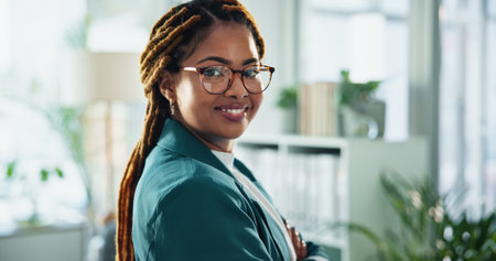 Happy, confident and portrait of businesswoman in office with positive attitude for legal career. Smile, glasses and face of professional African female attorney with pride for law case in workplace.の写真素材