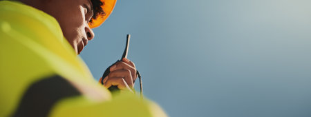 Blue sky, construction and man with radio in city for communication, contact and maintenance. Mockup space, architecture banner and worker for planning, building infrastructure and engineeringの写真素材