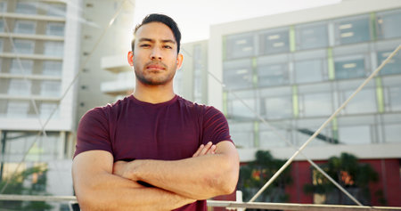 Portrait, fitness and man in city, arms crossed and urban town with buildings, sports and exercise. Serious face, healthy athlete or person in street, training and wellness with workout and prideの写真素材