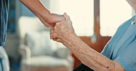 Senior woman, holding hands and support in nursing home for care, help and kindness. Closeup, comfort and patient in retirement for empathy, medical assistance or health with nurse in rehabilitationの写真素材