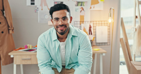Creative, development and portrait of fashion designer man in textile workshop for production. Clothes, confident and glasses with happy style director at desk in office for manufacturing processの写真素材