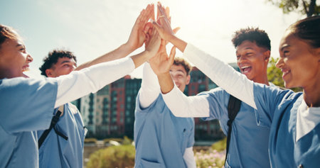 Medical success, students and happy with hands together outdoor for training program support or board exam results. Diversity team, people and high five on campus for healthcare practice or educationの写真素材